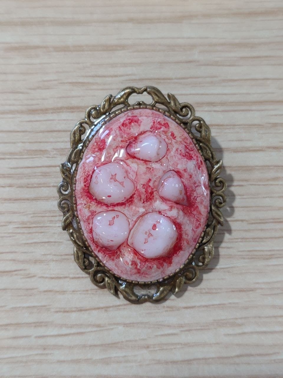 Broche de teratoma con marco dorado, modelo A, vista frontal