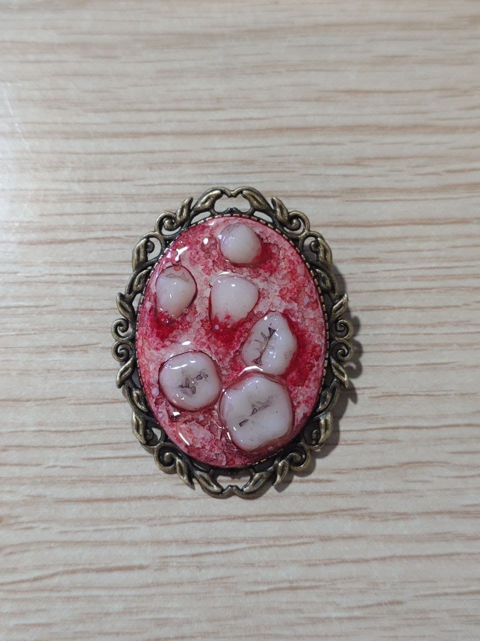 Broche de teratoma con marco dorado, modelo B, vista frontal