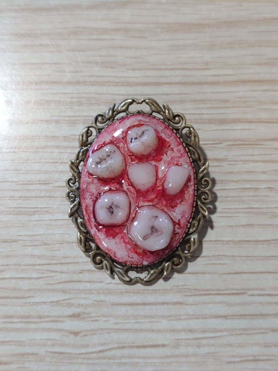 Broche de teratoma con marco dorado, modelo C, vista frontal