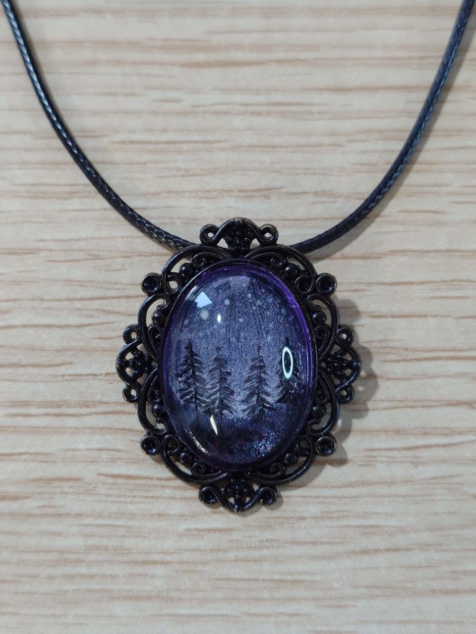 Collar artesanal con escena de bosque estrellado y marco negro